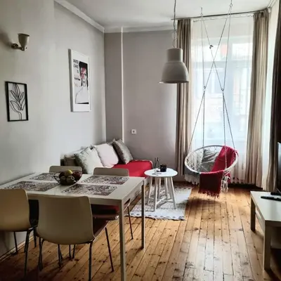 a living room with a table and a red couch at Cozy & Stylish apartment in the heart of Sofia in Sofia
