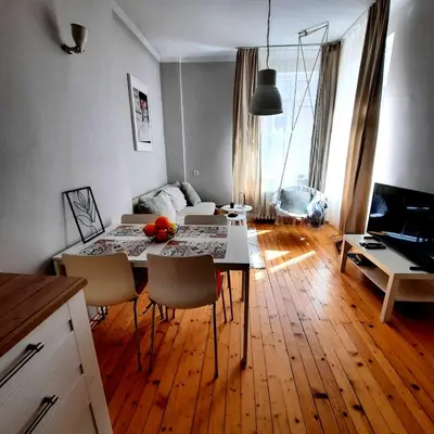 a living room with a table and chairs in it at Cozy & Stylish apartment in the heart of Sofia in Sofia