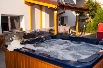 a jacuzzi tub in a backyard with a couch at Допълнителна къща за гости Ози 2 in Ovchartsi