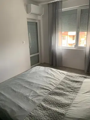 a white bedroom with a bed and a window at Pazardzhik suite home in Pazardzhik