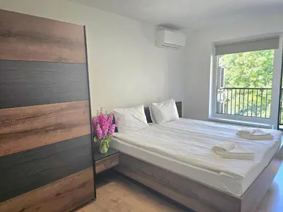 a bedroom with a bed with a window and flowers at Hotel Adria in Sofia
