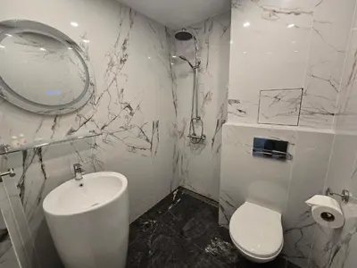 a white bathroom with a sink and a toilet at Hotel Adria in Sofia
