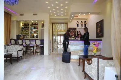 two women standing in a bar with their luggage at Hotel Adria in Sofia