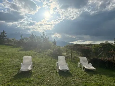 three white chairs sitting in the grass on a field at Panorama Bansko in Bansko