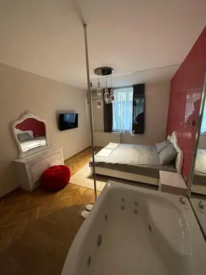 a bathroom with a tub and a bedroom with a bed at Lux apartments Top center in Sofia