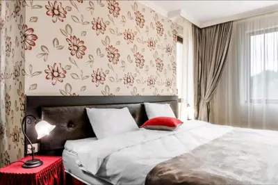 a bedroom with a large bed and a red table at Astrea Deluxe in Hisarya