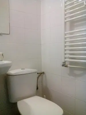 a white bathroom with a toilet and a window at Studio Rositza in Sofia