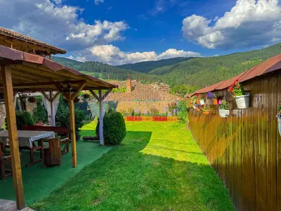 a garden with a wooden fence and a green yard at Златкова къща in Koprivshtitsa