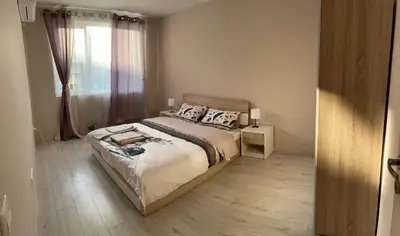 a bedroom with a large bed and a window at Apartment Mladost 2 - Free Parking in Sofia