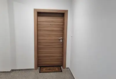 a wooden door in a white wall with a welcome sign at Luxury Quiet Apartment in the City Center in Plovdiv