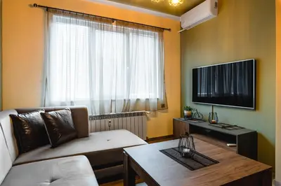 a living room with a couch and a table and a tv at Eagles' Bridge - 1BD Flat with Desk by Flat Mаnager in Sofia