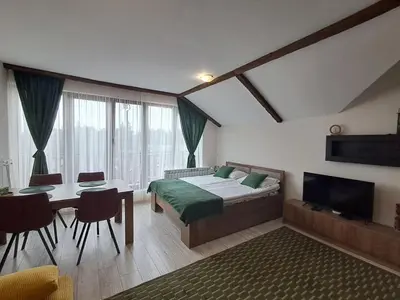 a bedroom with a bed and a table and a television at Large studio with view in Borovets Gardens in Borovets