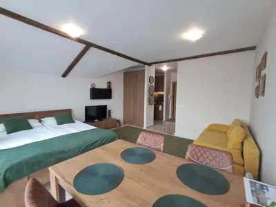 a bedroom with a bed and a table and a couch at Large studio with view in Borovets Gardens in Borovets