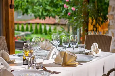 a table with wine glasses and napkins on it at Къща за приятели Недкови in Vasil Levski