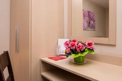 a vase of pink flowers on a counter in a room at Family Hotel Madrid in Sofia