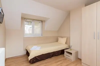a small bedroom with a bed and a window at Family Hotel Madrid in Sofia