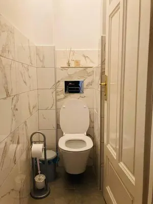 a bathroom with a white toilet in a room at CityPulse Apt in Ideal Center w Working Space in Sofia