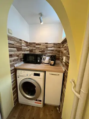 a washer and dryer in a room with a brick wall at CityPulse Apt in Ideal Center w Working Space in Sofia