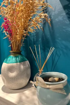 a vase with flowers and a bowl of rocks on a table at Contemporary Charm in Old Sofia in Sofia