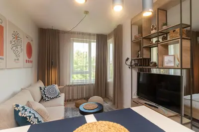a living room with a couch and a tv at Heart of Sofia Studio in Sofia