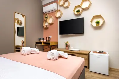 a room with two beds and a flat screen tv at Kapana Guest House on Central Pedestrian street with Parking included in Plovdiv