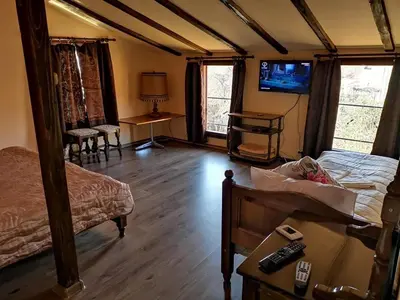 a bedroom with a bed and a table and a television at Къща за гости Старата череша село Раждавица in Rzhdavitsa