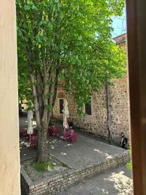 a courtyard with tables and chairs and a tree at 4 Rooms in Plovdiv