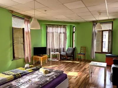 a room with green walls and a bed and a couch at 4 Rooms in Plovdiv