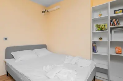 a bedroom with a bed with white sheets and a book shelf at The Honeycomb Hideaway by Flat Mаnager in Sofia