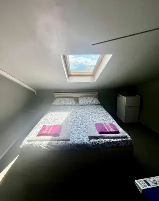 a bed in a small room with a window at Easy rooms in Sofia