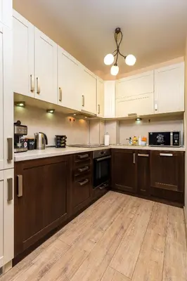 a large kitchen with wooden floors and white cabinets at South Plovdiv - 2BD Flat with Balcony by Flat Mаnager in Plovdiv