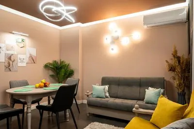 a living room with a couch and a table at Какао Апартамент Велинград in Velingrad
