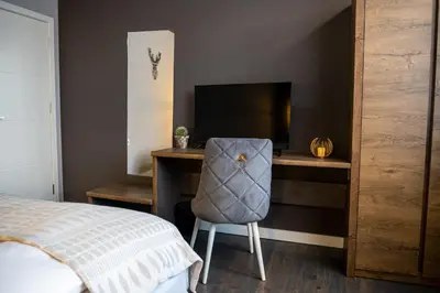 a bedroom with a desk with a chair and a television at Какао Апартамент Велинград in Velingrad