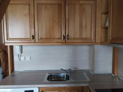a kitchen with wooden cabinets and a sink at Piringolf apartment in Razlog