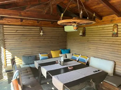 a dining room with a table and a couch at Guest House EGO in Bratsigovo