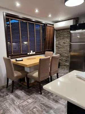 a kitchen with a table and chairs and a window at Guest House EGO in Bratsigovo