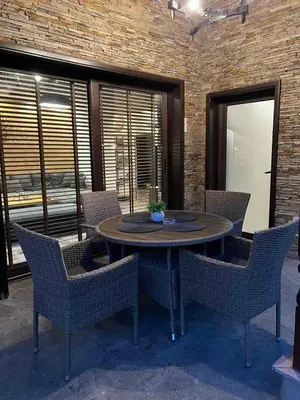 a table and chairs in a room with a brick wall at Guest House EGO in Bratsigovo