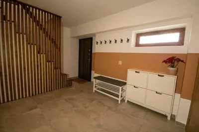 a living room with a staircase and a cabinet with a plant at Green Villa in Saparewo