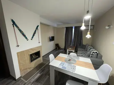 a living room with a couch and a table and a fireplace at Аpartment B201 Grand Bansko 1 in Bansko