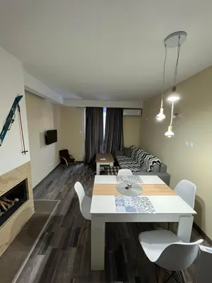 a living room with a table and chairs and a couch at Аpartment B201 Grand Bansko 1 in Bansko
