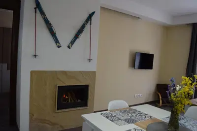 a living room with a fireplace and a table at Аpartment B201 Grand Bansko 1 in Bansko