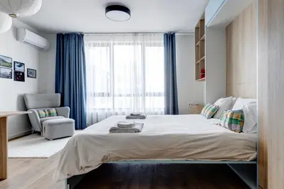 a bedroom with a large bed and a chair at New Studio - 300m Subway - 10 Mins City Centre in Sofia