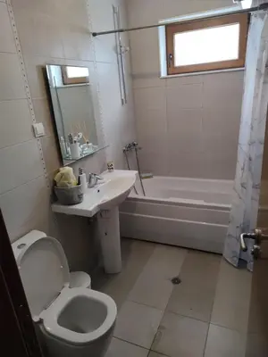 a bathroom with a toilet and a sink and a tub at Апартамент за гости Виктория in Chepelare