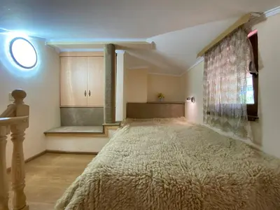 a bedroom with a large bed with a window at Белевската къща с беседка Belevska House with gazebo in Smolyan