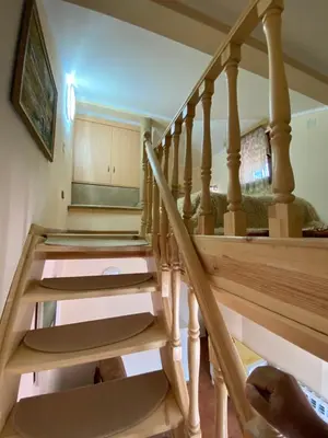 a set of stairs in a home with a wooden stair case at Белевската къща с беседка Belevska House with gazebo in Smolyan