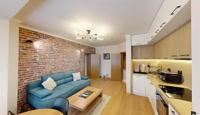 a living room with a blue couch and a brick wall at Апартамент в топ център София 5 Corners in Sofia