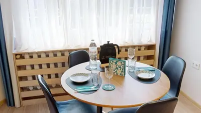 a table with chairs and plates and glasses on it at Апартамент в топ център София 5 Corners in Sofia