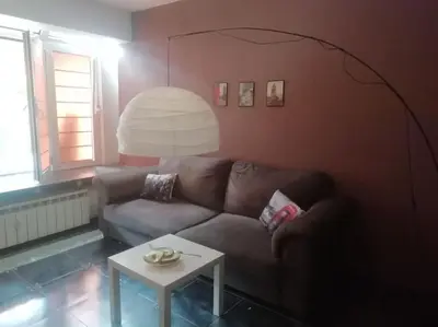 a living room with a couch and a table at Sofia Palms: Modern apartment with a large terrace in Sofia