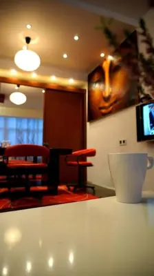 a room with a table and chairs and a tv at Sofia Zen - on Metro, ultra fast Wi-Fi in Sofia