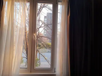 a window with white curtains and a view of a city at Sofia Zen - on Metro, ultra fast Wi-Fi in Sofia